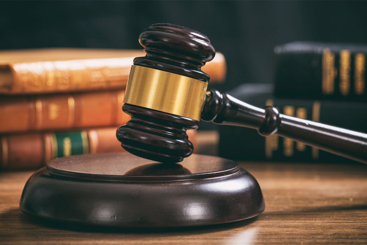 Judge's gavel resting on a block in front of a stack of law books. | Forensic Discovery