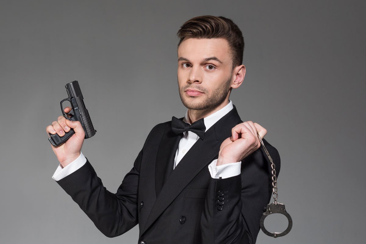 Man in tuxedo holding a handgun and handcuffs. | Forensic Discovery