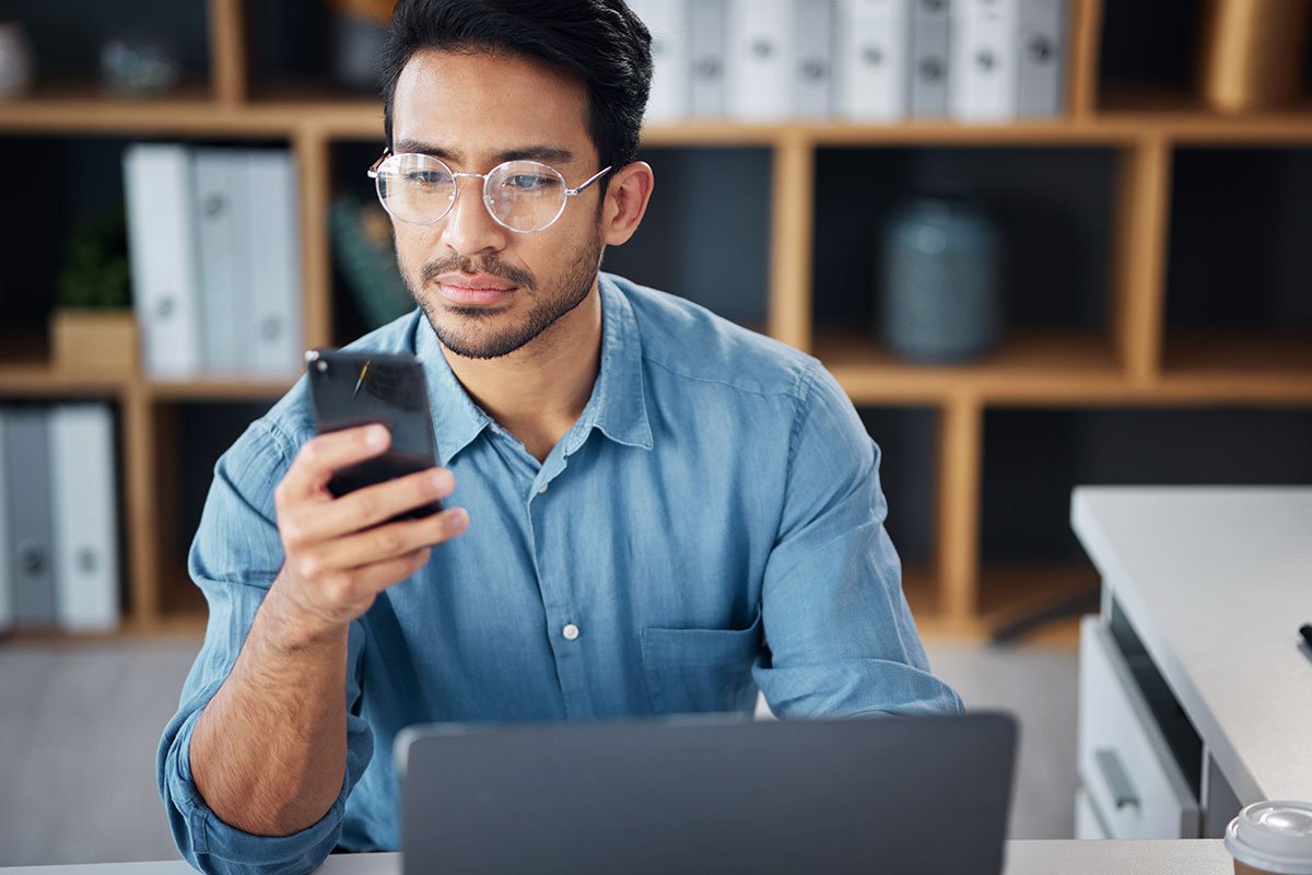 Man in glasses looking at his phone. | Forensic Discovery